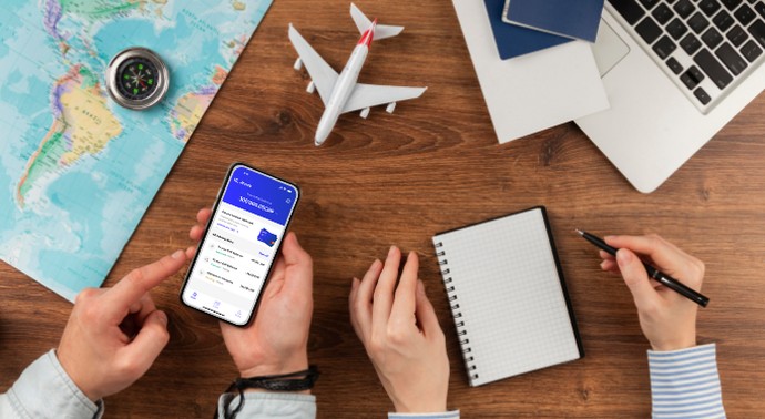 Travel expense management on the amnis app shown on a phone at a travel-planning desk